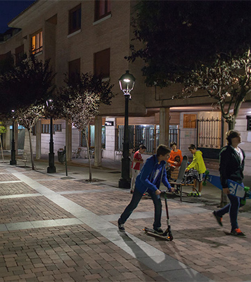 أشخاص يتجولون في شوارع بالنثيا ليلاً وهي مضاءة باستخدام إضاءات Philips